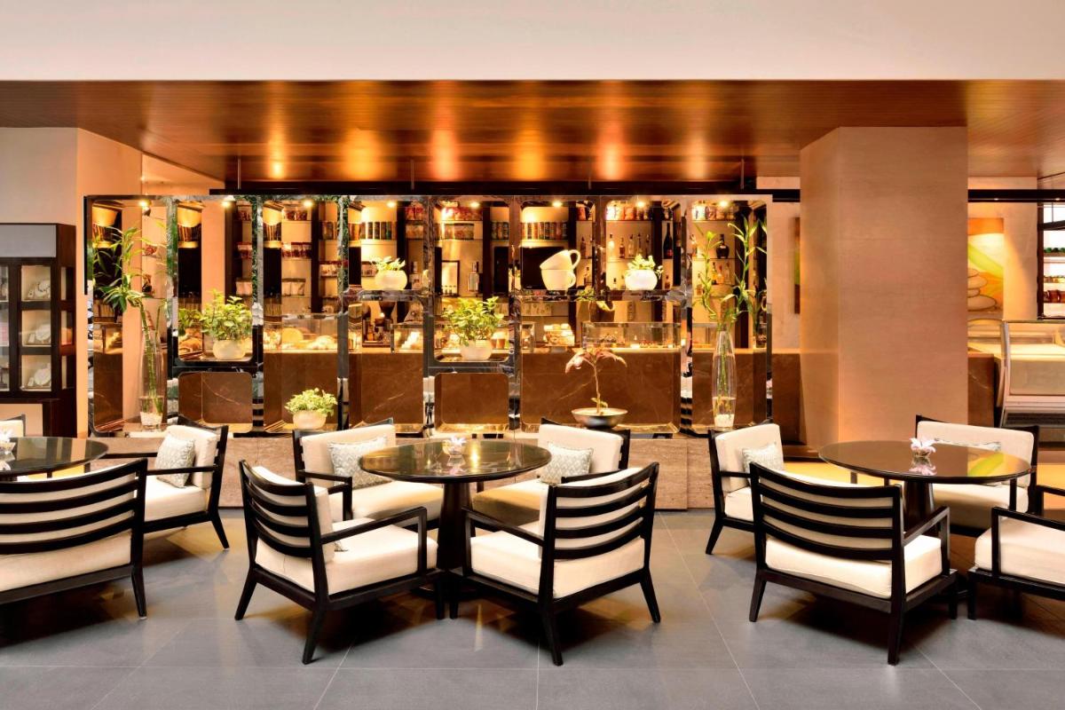 a dining room with tables and chairs and a store at The Westin Hyderabad Mindspace in Hyderabad