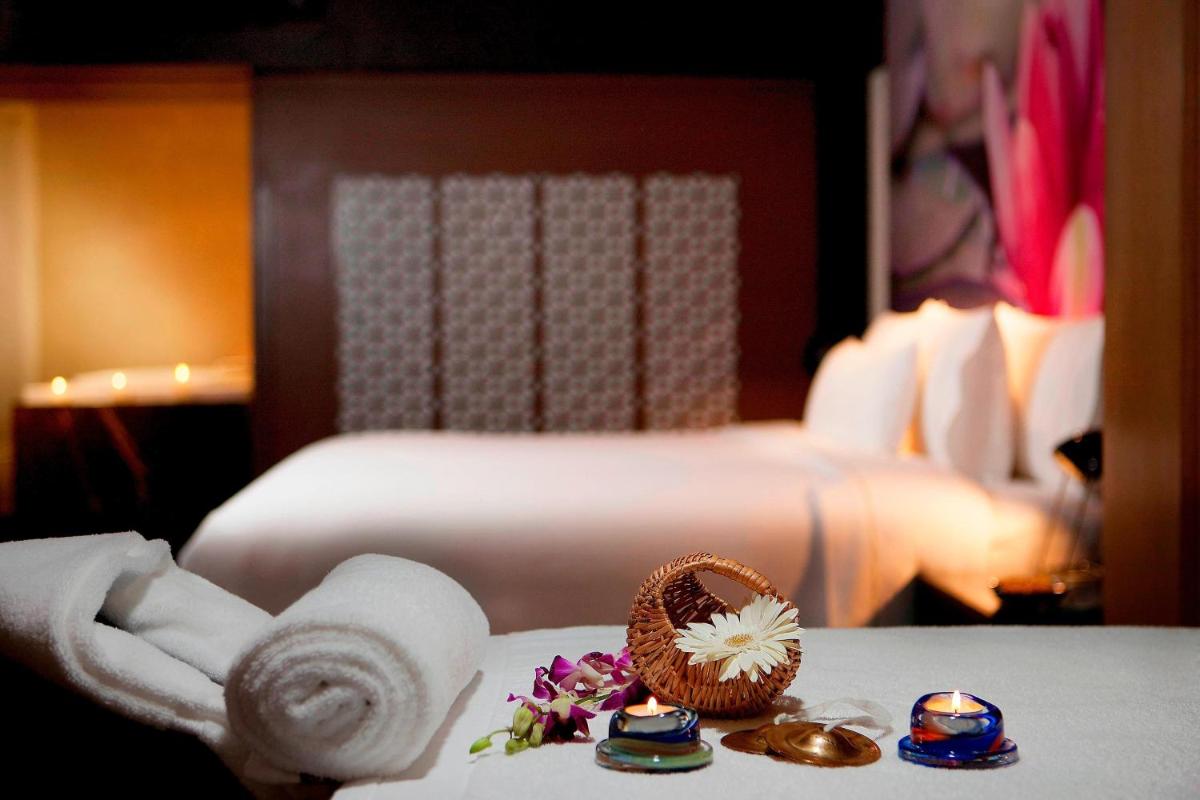 a hotel room with a bed and towels on a table at The Westin Hyderabad Mindspace in Hyderabad