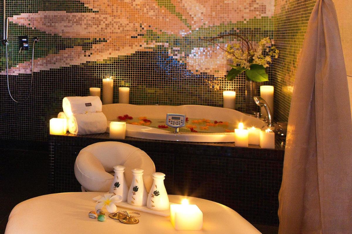 a bathroom with candles and a toilet and a sink at The Westin Hyderabad Mindspace in Hyderabad