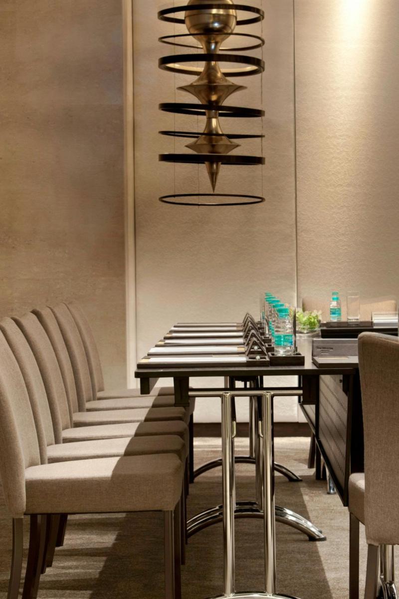 a dining room with chairs and a table and a chandelier at The Westin Hyderabad Mindspace in Hyderabad