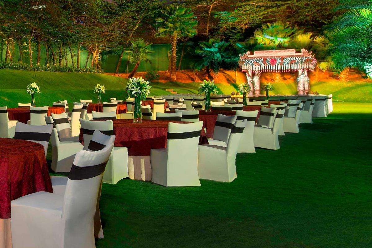 a group of tables and chairs in a field at The Westin Hyderabad Mindspace in Hyderabad
