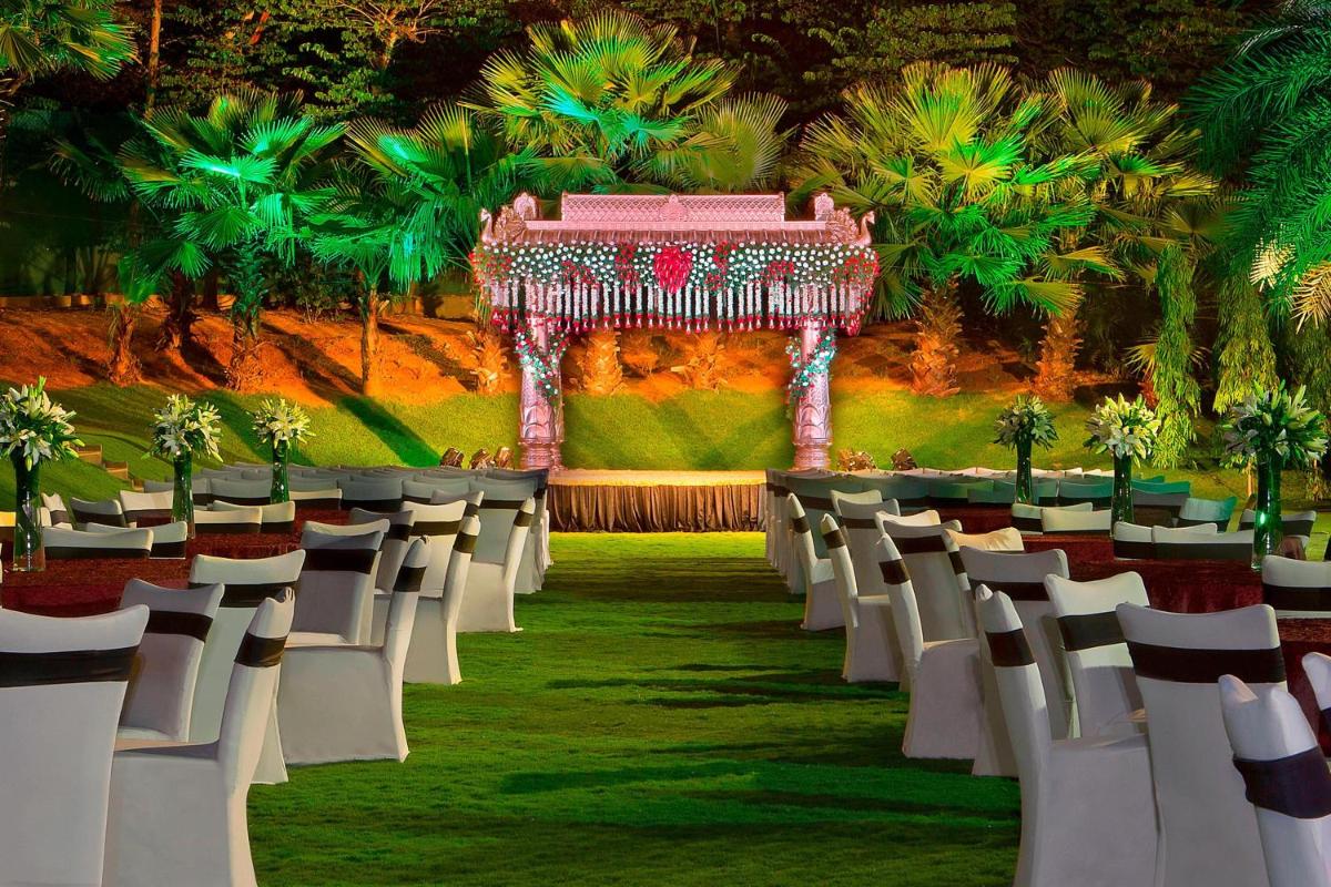 an aisle with white chairs and a gazebo at The Westin Hyderabad Mindspace in Hyderabad