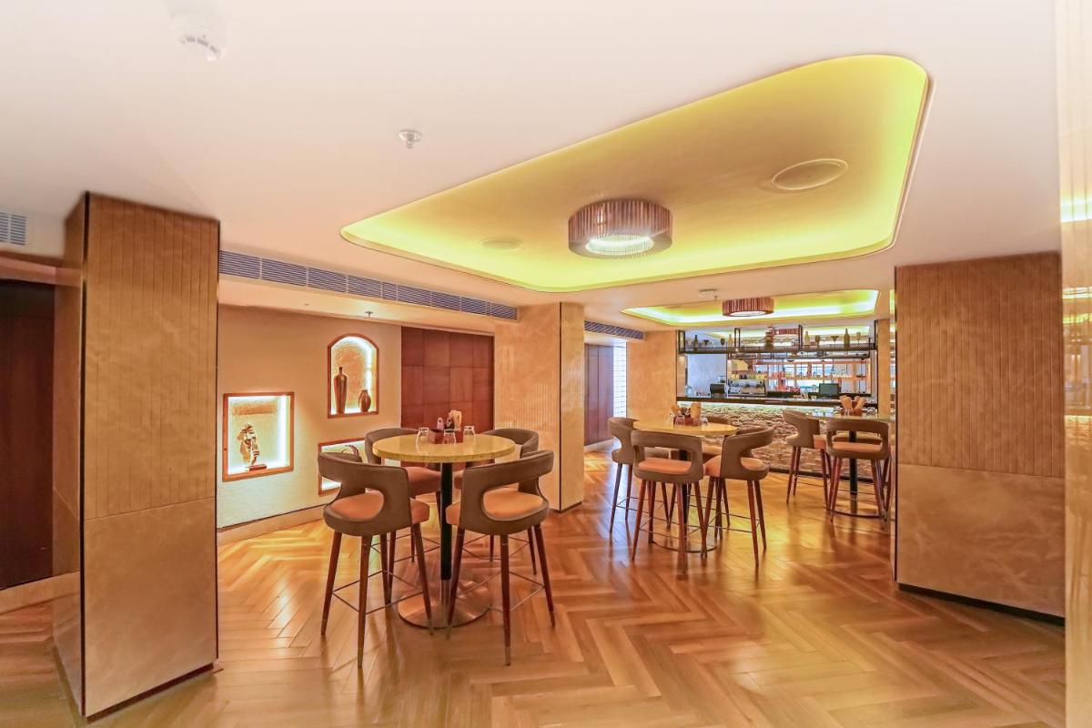 a dining room with a yellow ceiling at Hyatt Place Haridwar in Haridwār