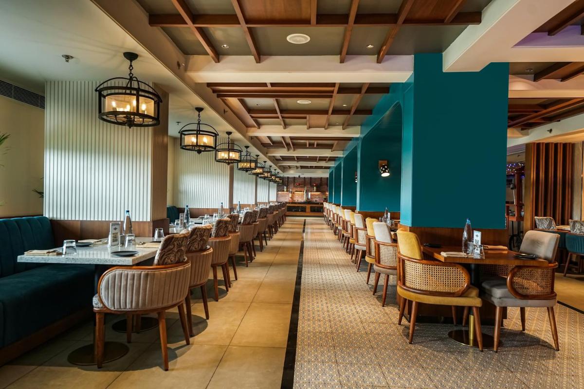 a long dining room with tables and chairs at Hyatt Place Haridwar in Haridwār