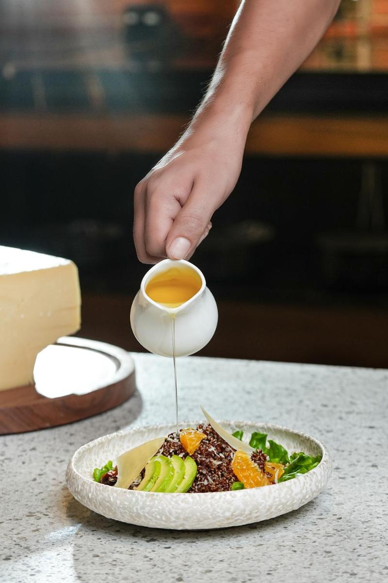 a person holding a cup of tea next to a plate of food at Hyatt Place Haridwar in Haridwār