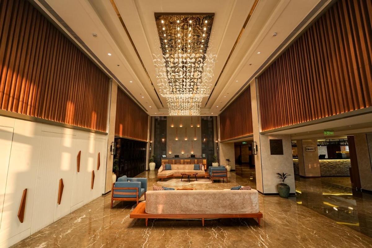 a lobby with a couch and chairs in a building at Hyatt Place Haridwar in Haridwār