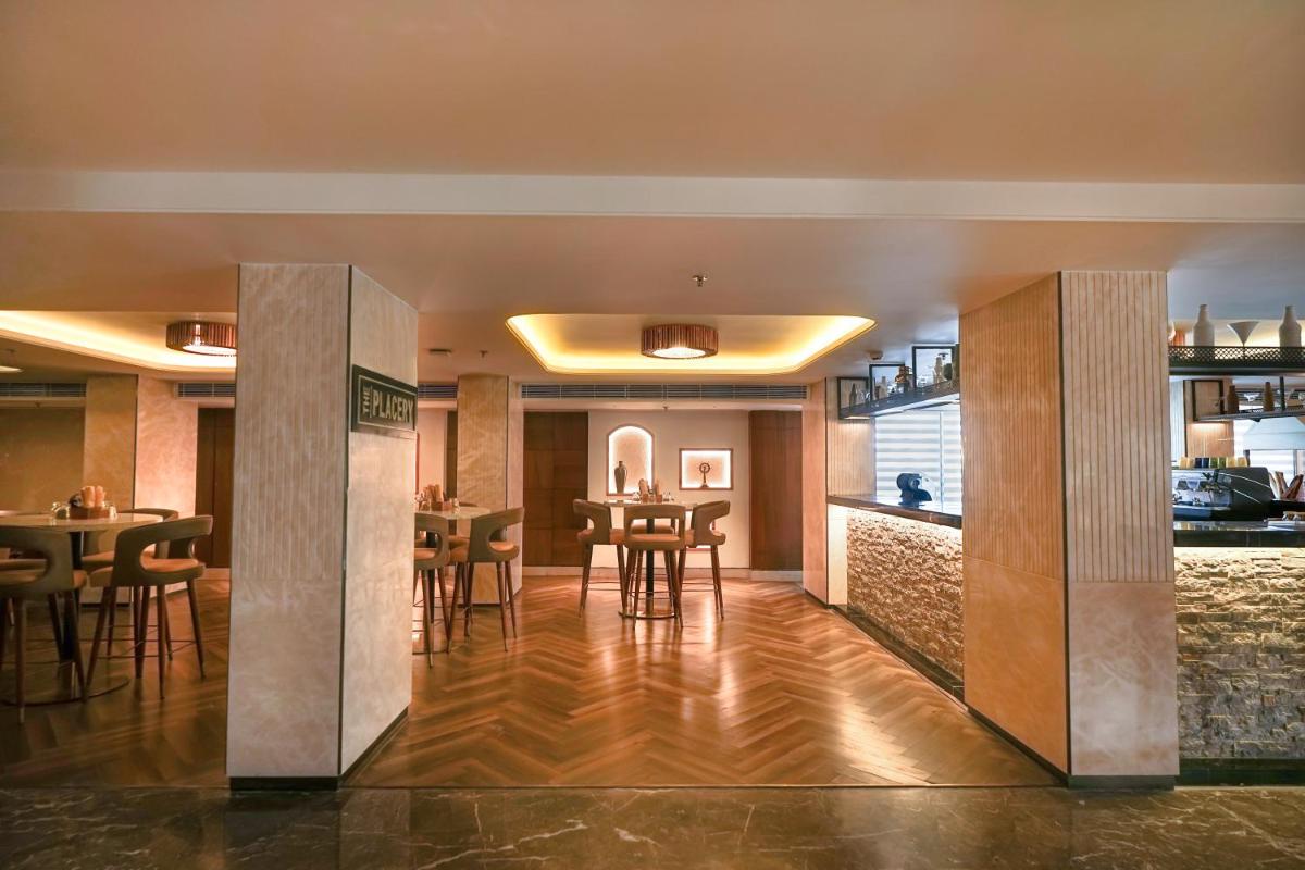 a dining area with tables and chairs in a restaurant at Hyatt Place Haridwar in Haridwār