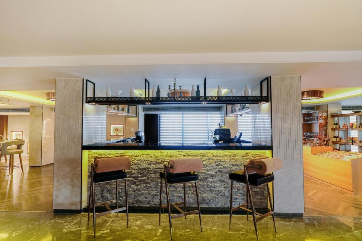 a kitchen with a bar with stools in a room at Hyatt Place Haridwar in Haridwār