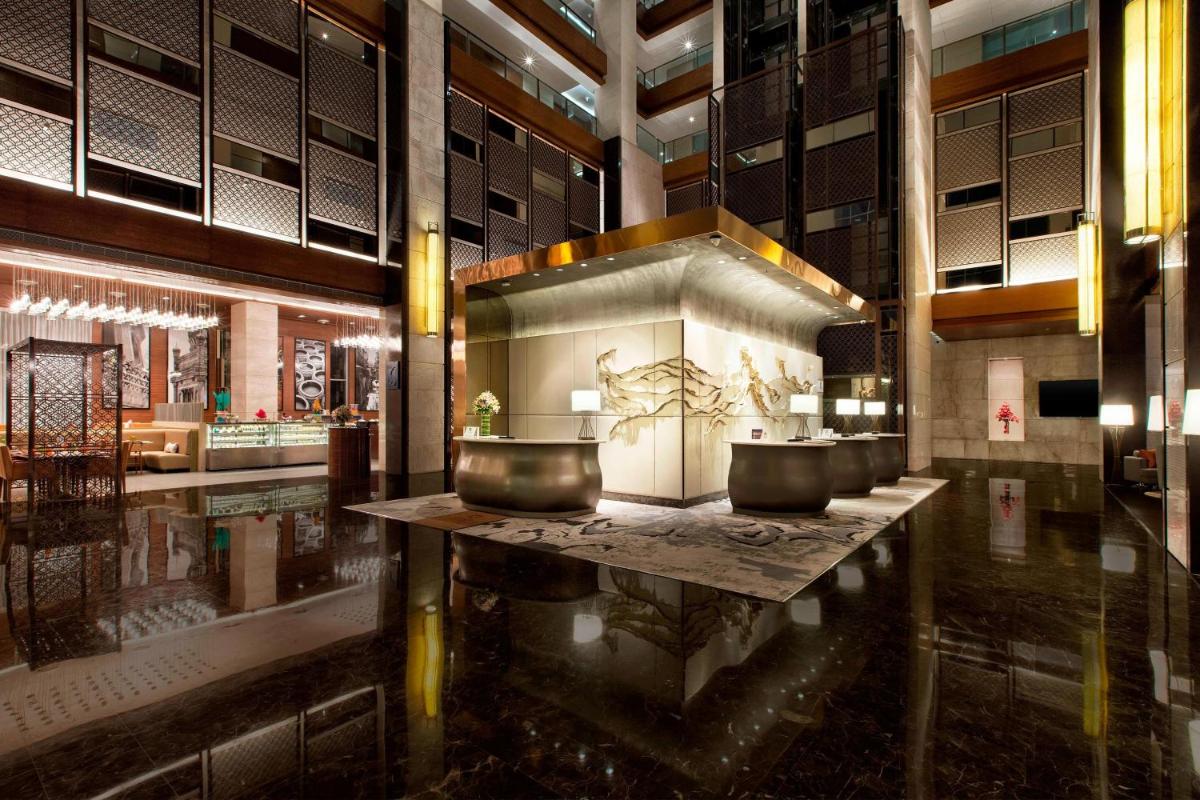 a bathroom with two sinks in a large building at Sheraton Hyderabad Hotel in Hyderabad