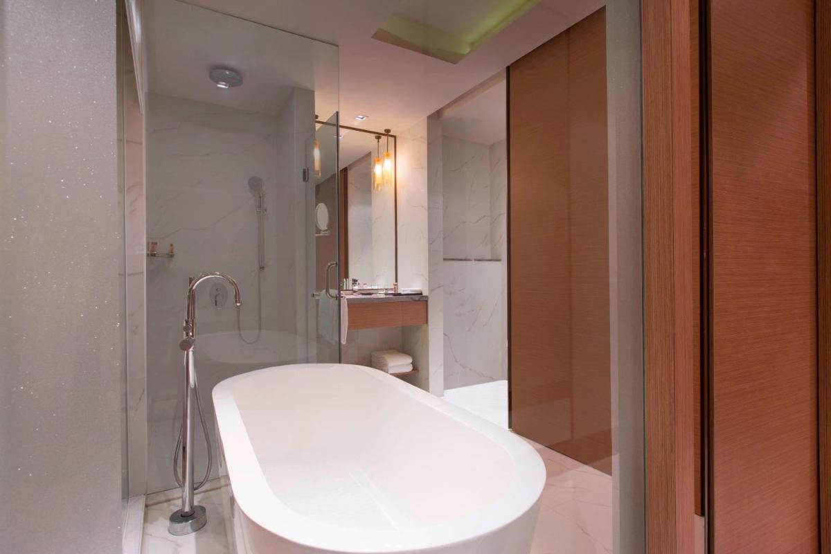 a bathroom with a shower and a white sink at Sheraton Hyderabad Hotel in Hyderabad