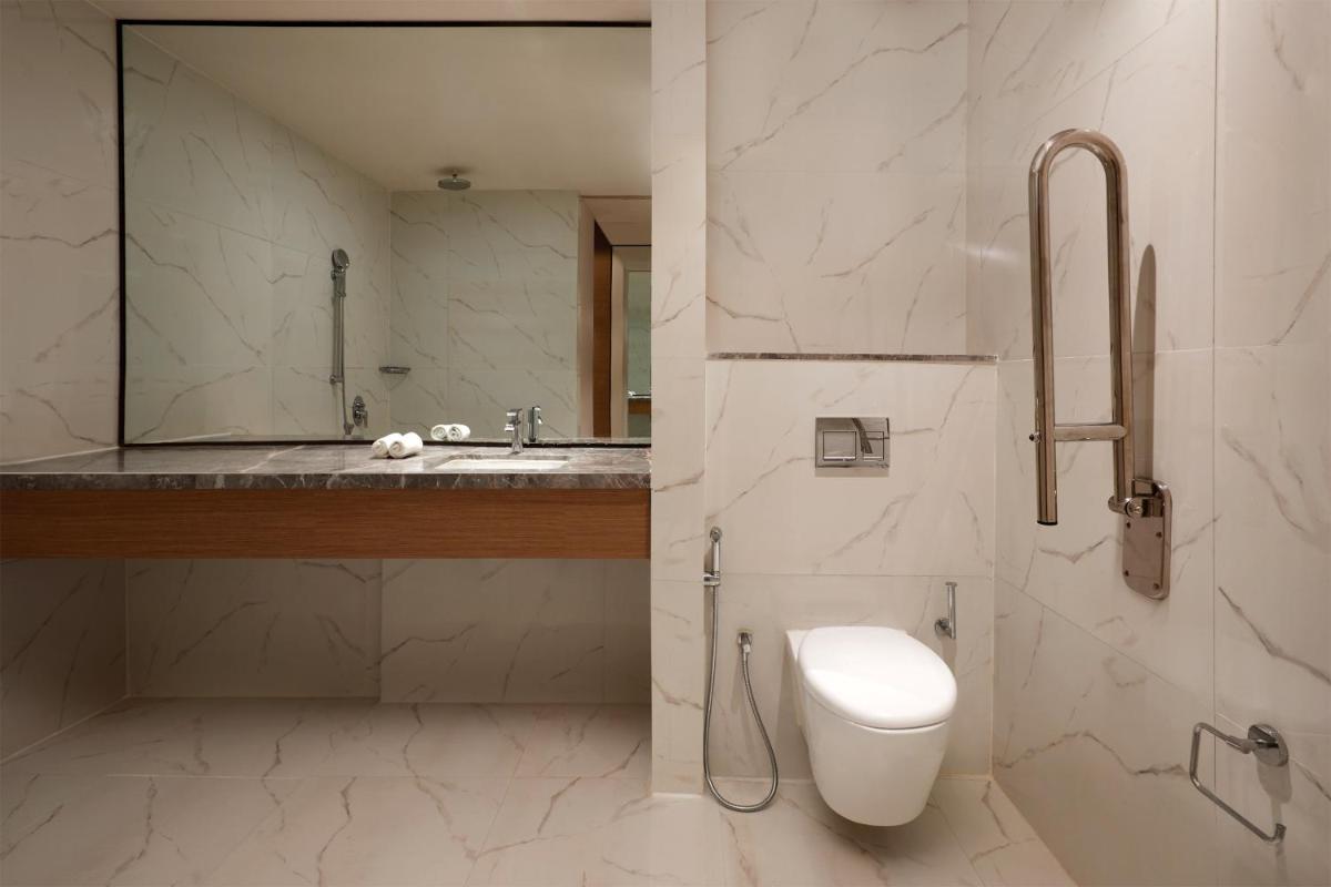 a bathroom with a toilet and a sink at Sheraton Hyderabad Hotel in Hyderabad