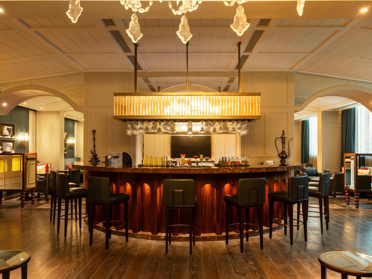 a bar in a large room with chairs at The Leela Hyderabad Banjara Hills in Hyderabad