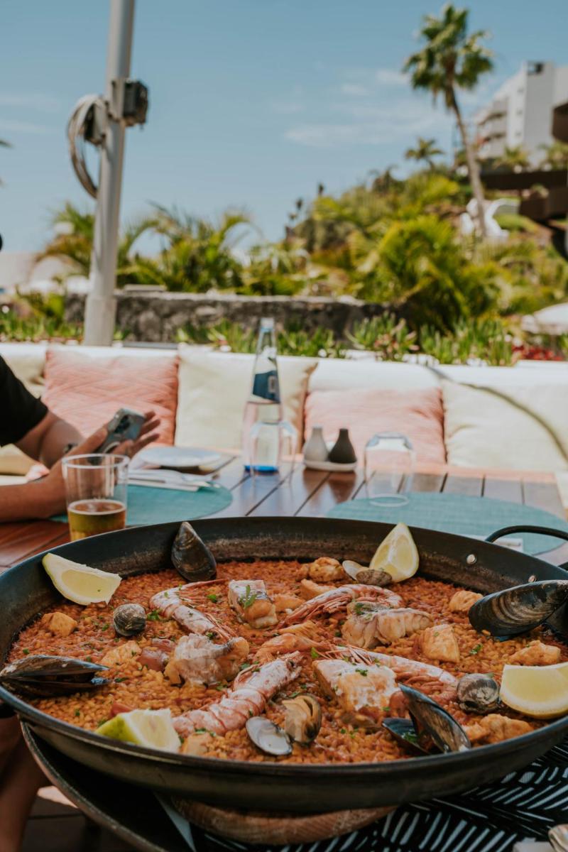 Una sartén con comida y mariscos sobre una mesa. en Hard Rock Hotel Tenerife, en Adeje