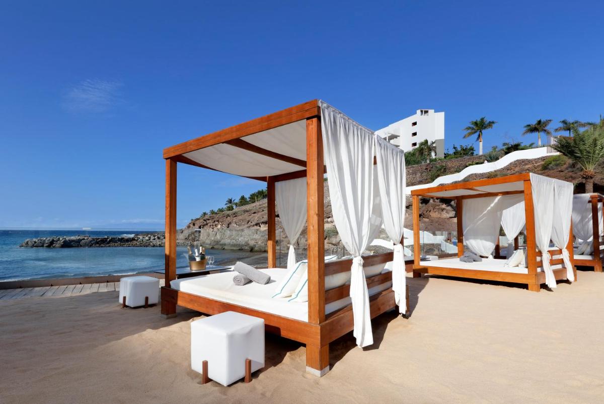 Dos camas en la playa junto al océano. en Hard Rock Hotel Tenerife, en Adeje