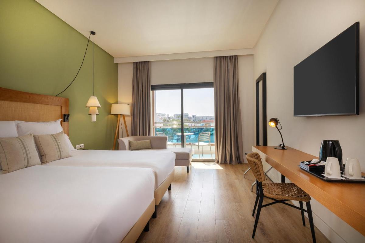 una habitación de hotel con una cama y un escritorio en AluaSoul Costa Adeje - Adults Only, en Adeje
