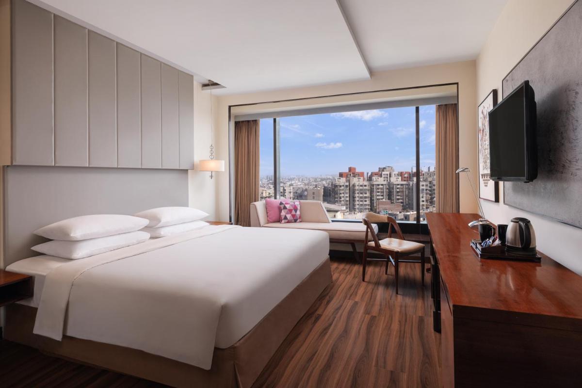 a hotel room with a large bed and a couch at Renaissance Ahmedabad Hotel in Ahmedabad