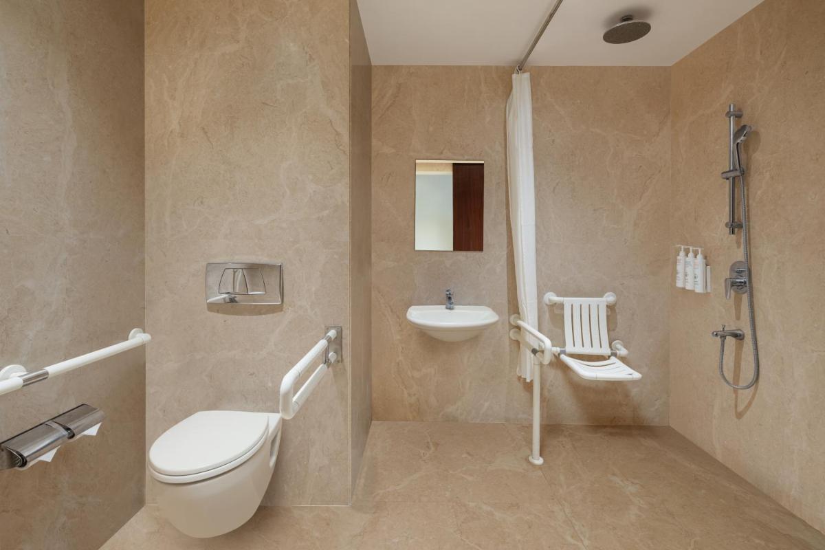 a bathroom with a toilet and a sink and a shower at Renaissance Ahmedabad Hotel in Ahmedabad