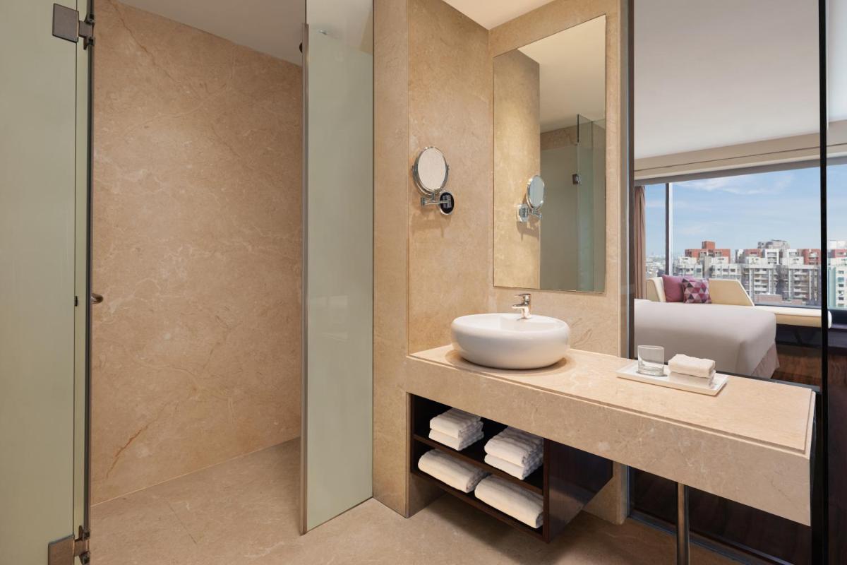 a bathroom with a sink and a mirror at Renaissance Ahmedabad Hotel in Ahmedabad