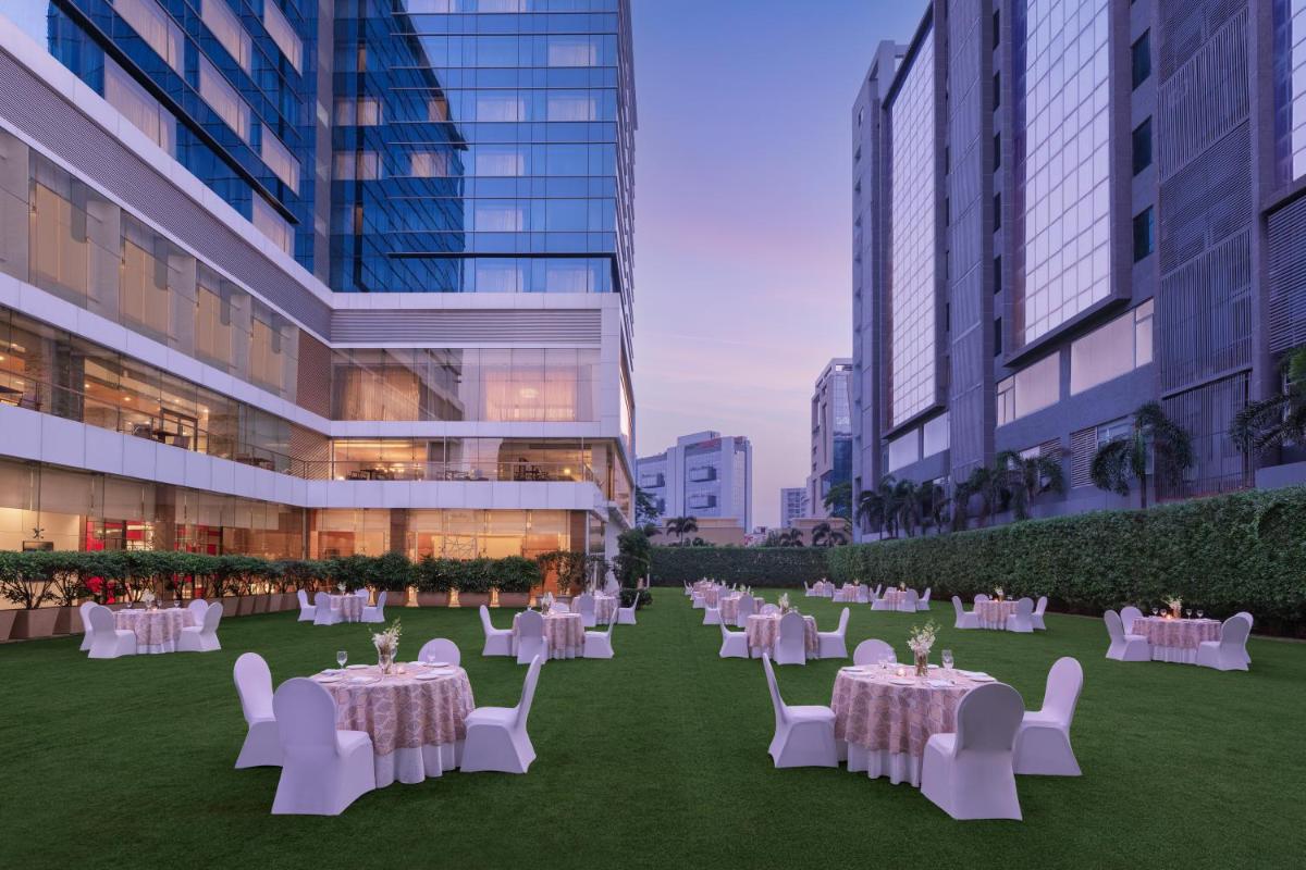 a banquet area with tables and chairs in a building at Renaissance Ahmedabad Hotel in Ahmedabad