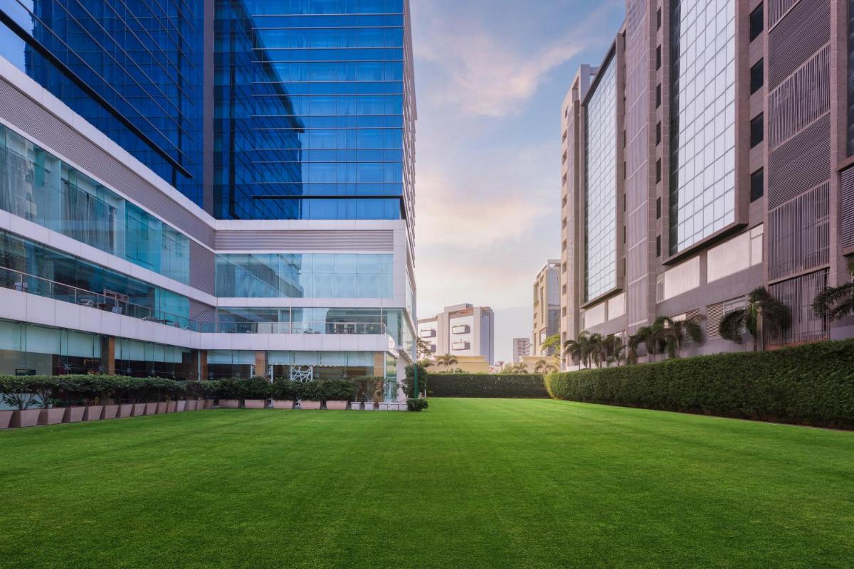 a green lawn in front of a tall building at Renaissance Ahmedabad Hotel in Ahmedabad