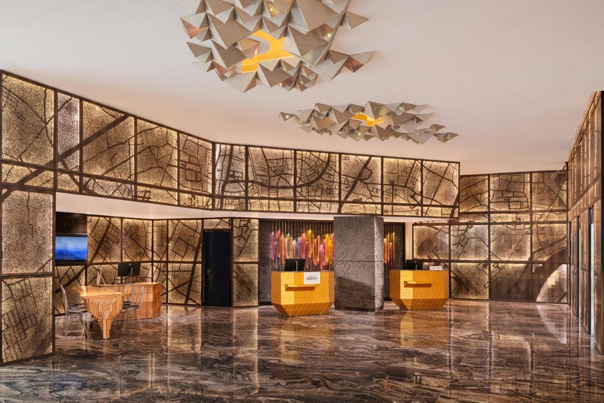 a lobby of a hotel with a wall of tiles at Renaissance Ahmedabad Hotel in Ahmedabad