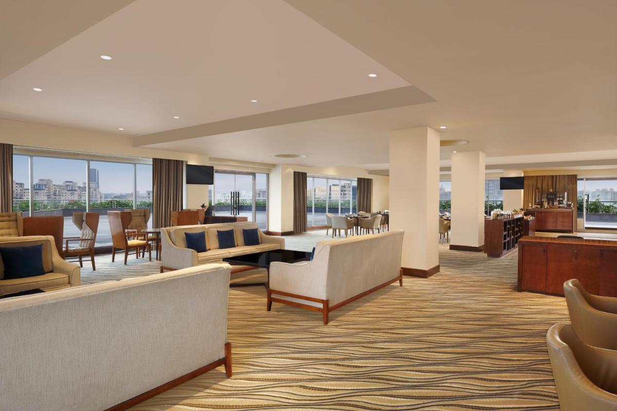 a hotel lobby with couches and tables and chairs at The Westin Pune Koregaon Park in Pune