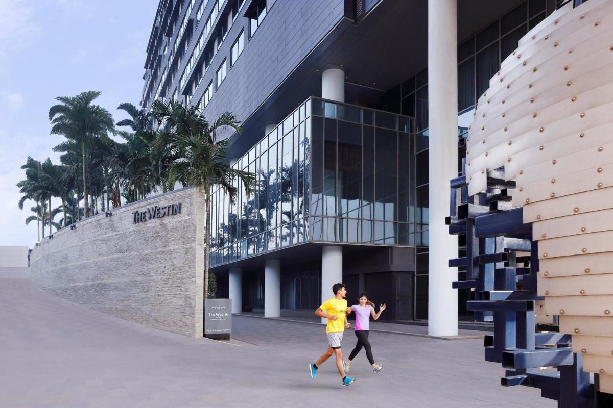 two people running in front of a building at The Westin Pune Koregaon Park in Pune