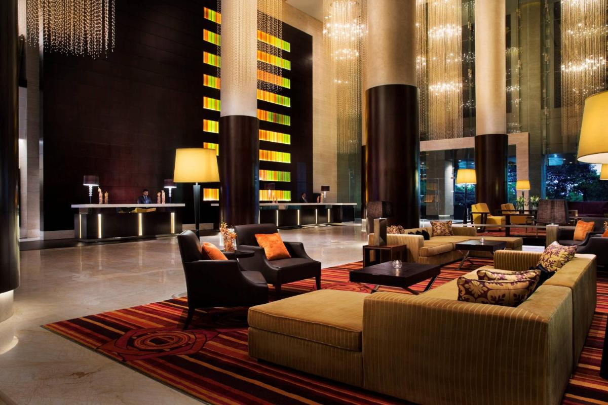 a lobby of a hotel with couches and chairs at JW Marriott Hotel Bengaluru in Bengaluru a lobby of a hotel with couches and chairs at JW Marriott Hotel Bengaluru in Bengaluru
