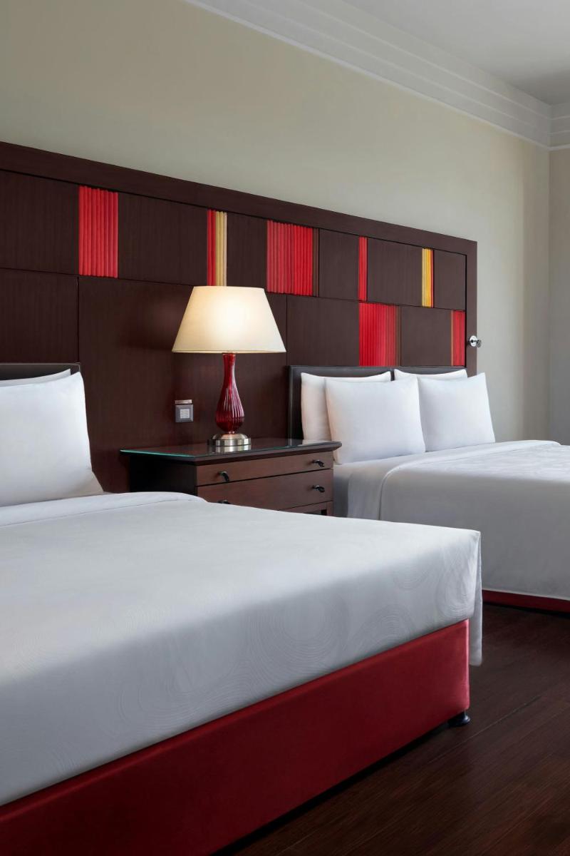 a hotel room with two beds and a table with a lamp at JW Marriott Hotel Bengaluru in Bengaluru