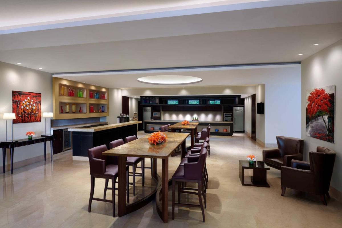 a dining room and kitchen with a table and chairs at JW Marriott Hotel Bengaluru in Bengaluru