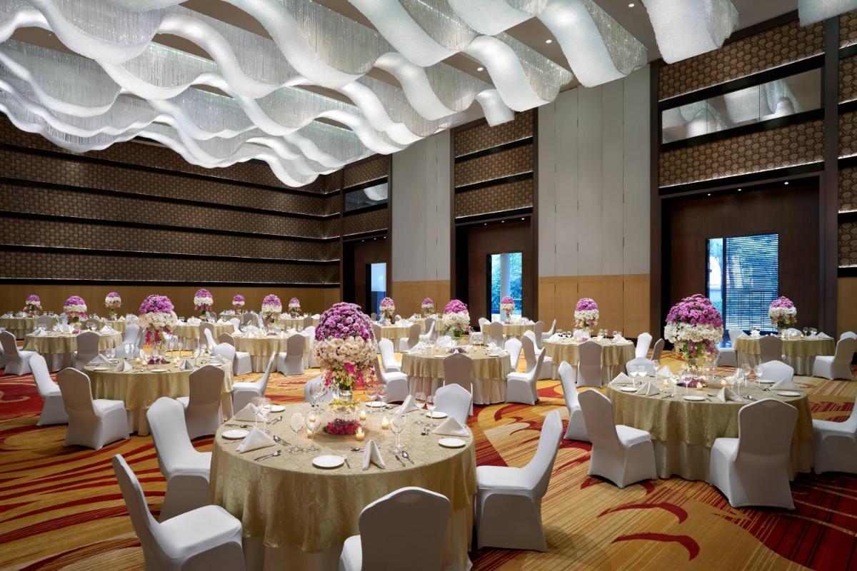 a conference room with tables and chairs and a ceiling at JW Marriott Hotel Bengaluru in Bengaluru