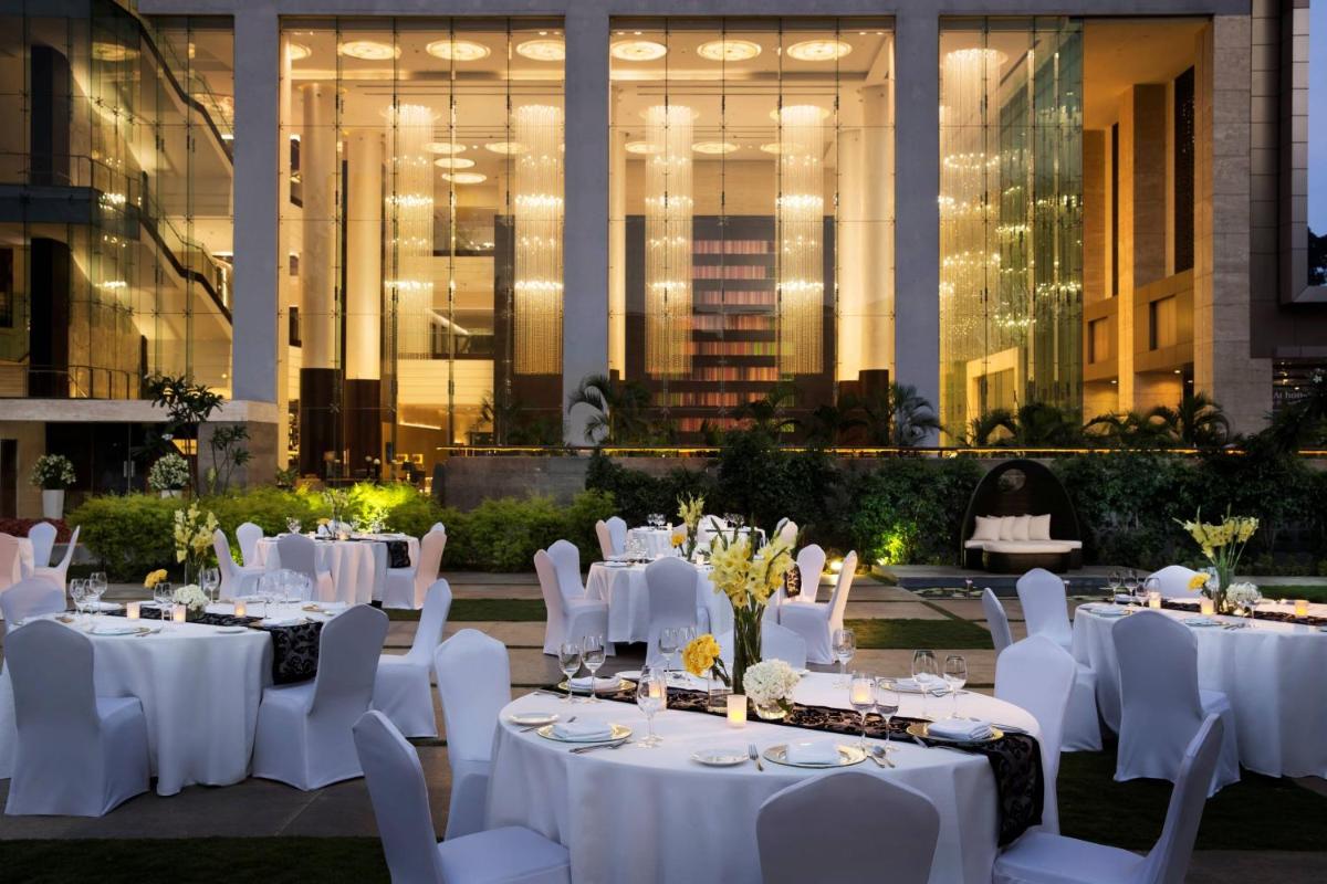 a group of tables with white table settings at JW Marriott Hotel Bengaluru in Bengaluru