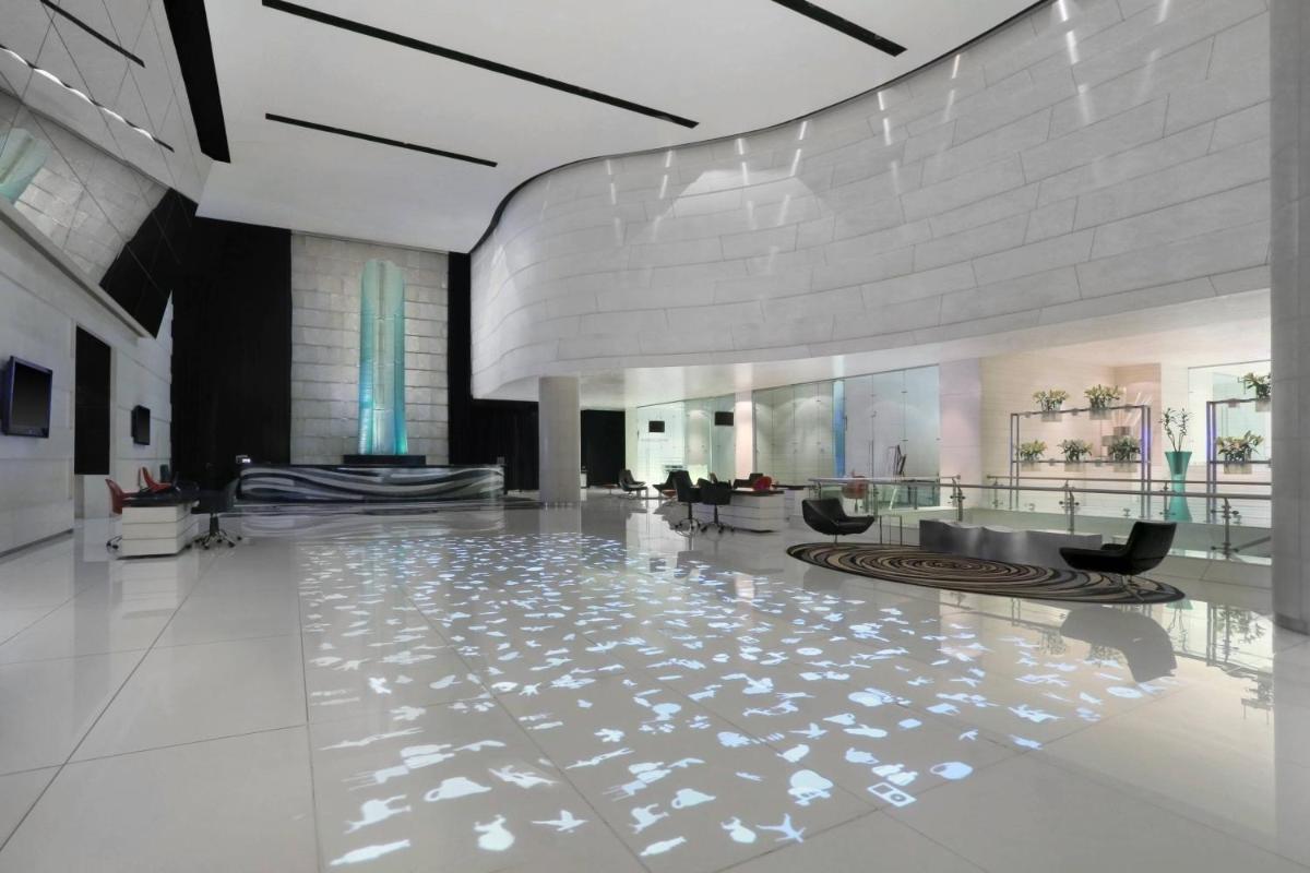 a lobby of a building with a shiny floor at Le Meridien New Delhi in New Delhi a lobby of a building with a shiny floor at Le Meridien New Delhi in New Delhi