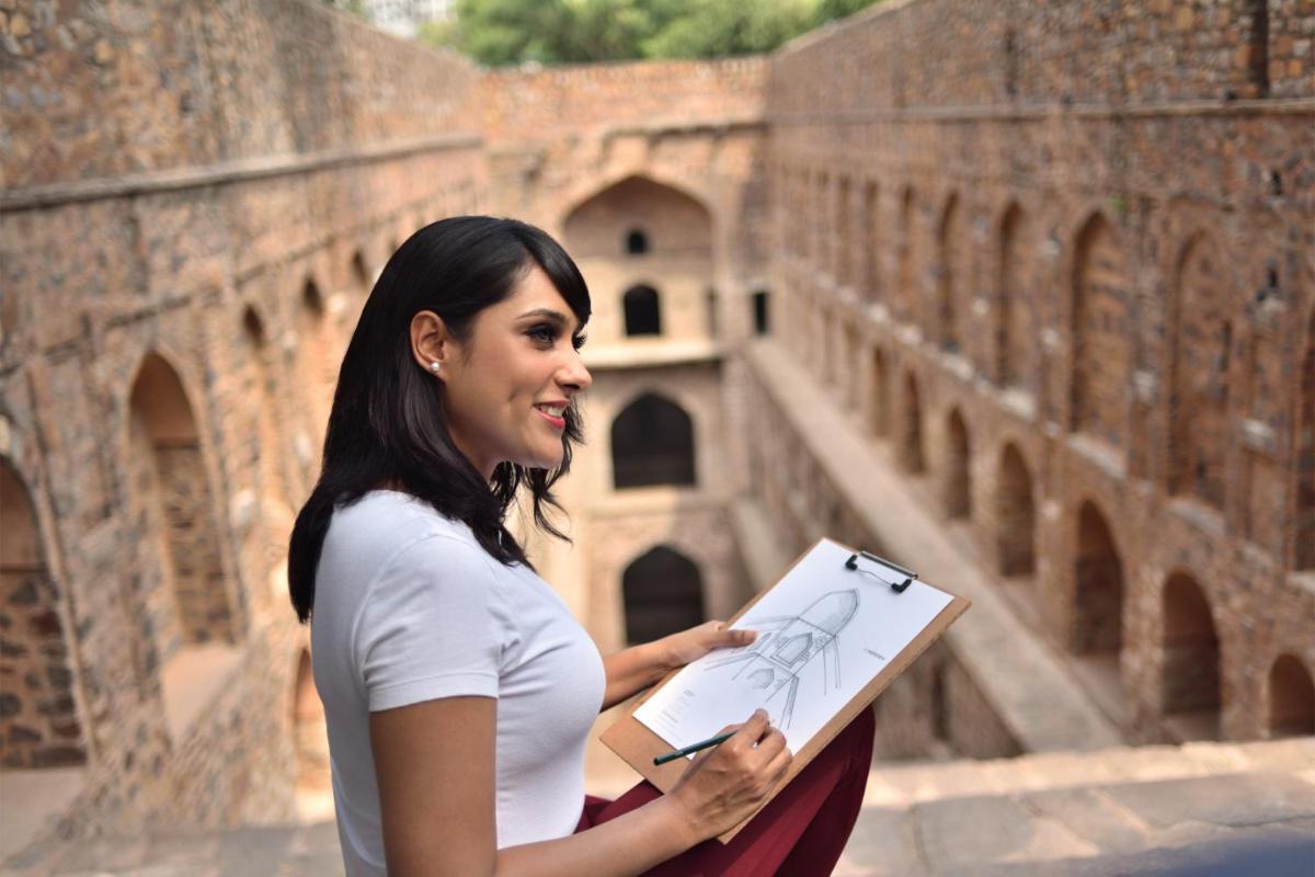 a woman standing in front of a building holding a drawing at Le Meridien New Delhi in New Delhi a woman standing in front of a building holding a drawing at Le Meridien New Delhi in New Delhi