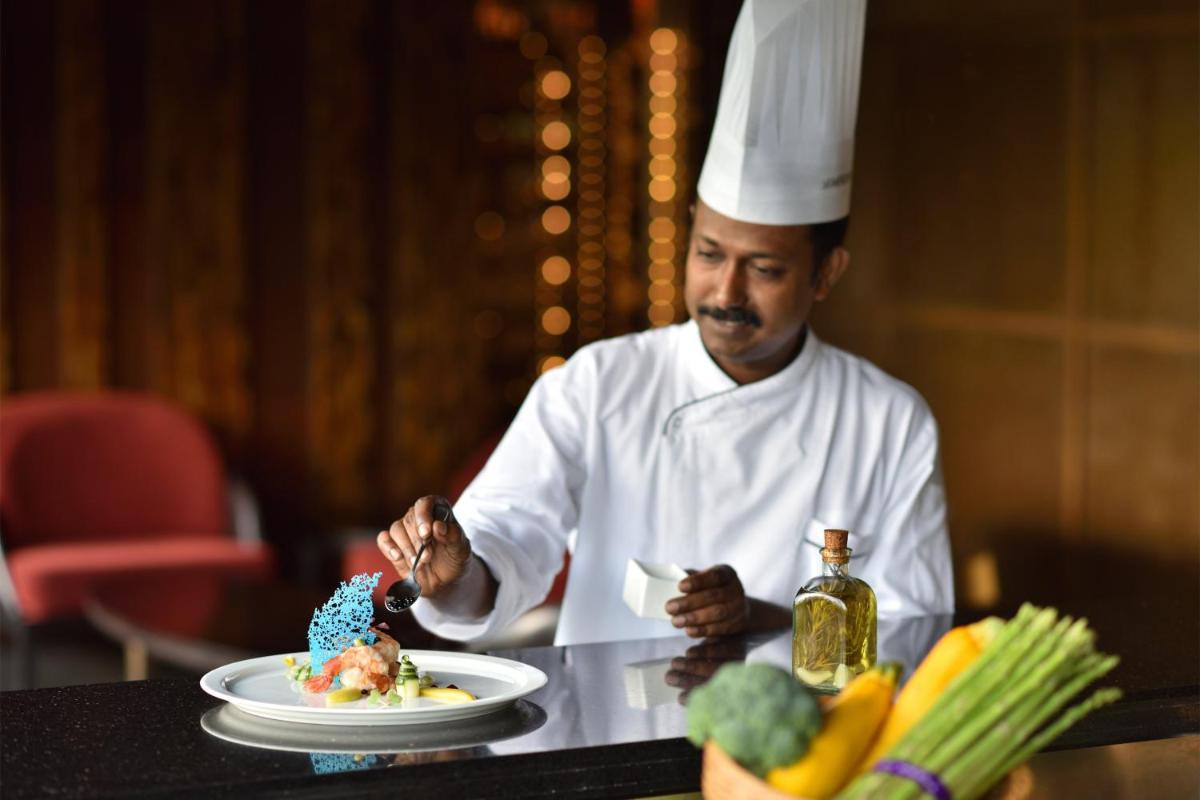 a man in a chefs hat eating a plate of food at Le Meridien New Delhi in New Delhi a man in a chefs hat eating a plate of food at Le Meridien New Delhi in New Delhi