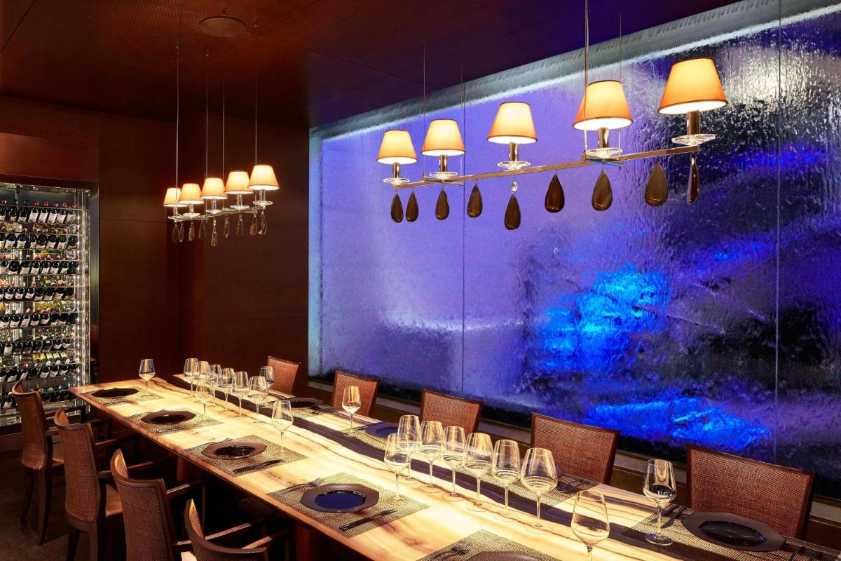 a long table in a room with a purple wall at Le Meridien New Delhi in New Delhi a long table in a room with a purple wall at Le Meridien New Delhi in New Delhi