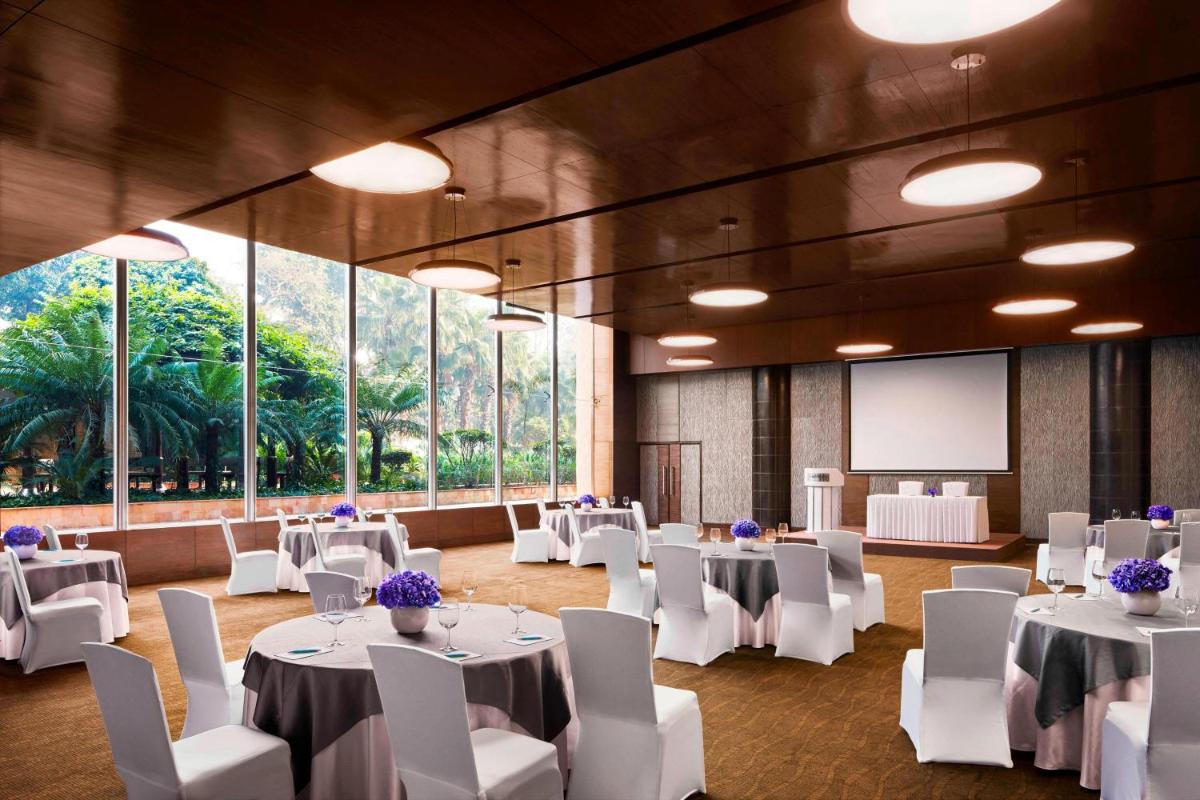 a banquet hall with white tables and white chairs at Le Meridien New Delhi in New Delhi a banquet hall with white tables and white chairs at Le Meridien New Delhi in New Delhi