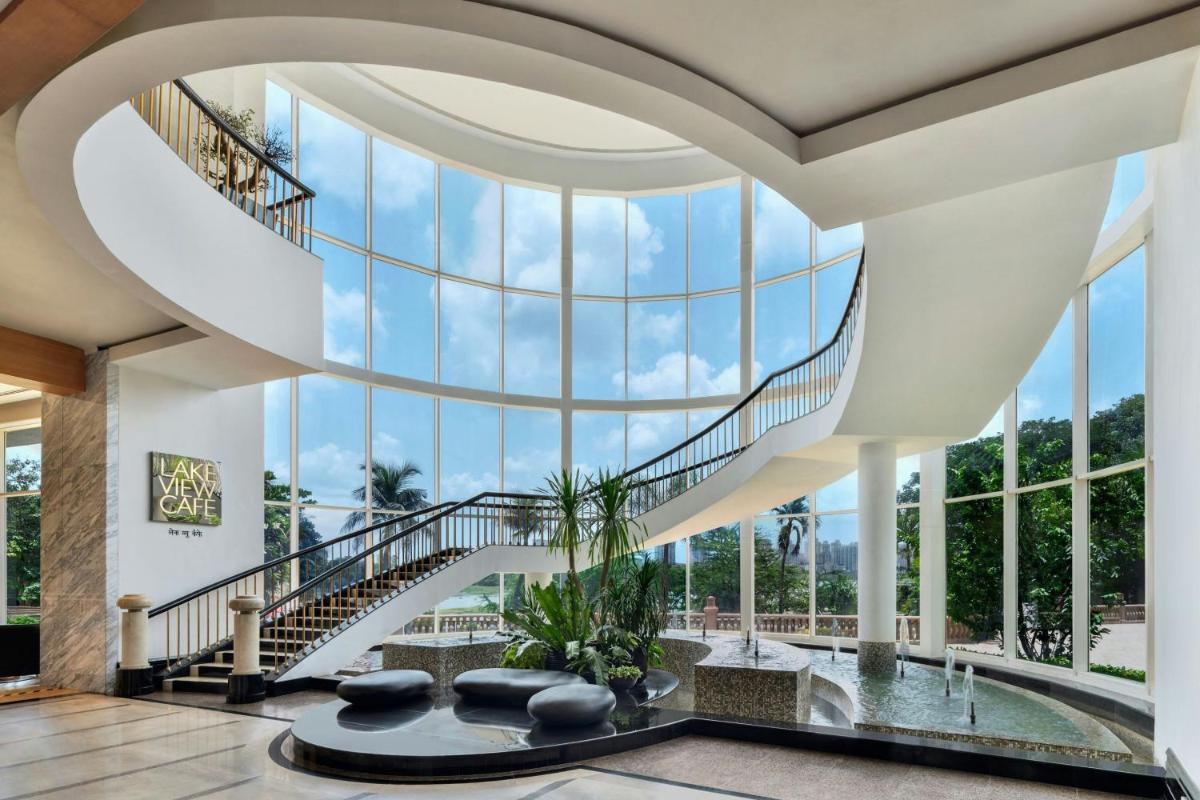 a large lobby with a spiral staircase and a pool at The Westin Mumbai Powai Lake in Mumbai