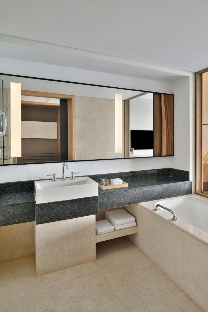 a bathroom with a sink and a large mirror at The Westin Mumbai Powai Lake in Mumbai