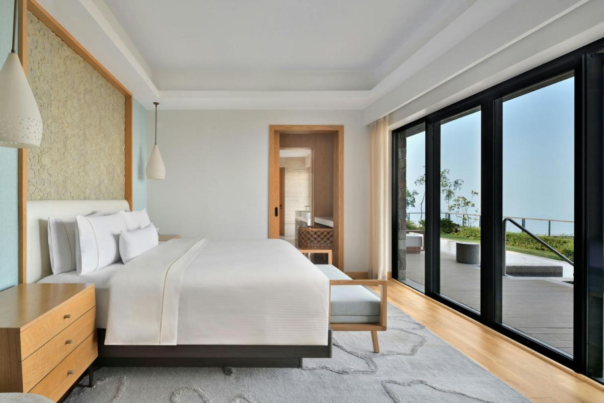 a bedroom with a white bed and a balcony at The Westin Resort & Spa Himalayas in Rishīkesh