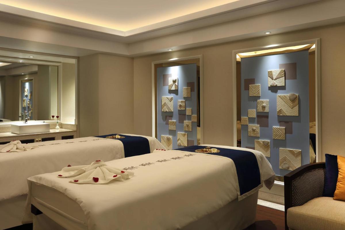 a hotel room with two beds and a sink at Sheraton Grand Pune Bund Garden Hotel in Pune