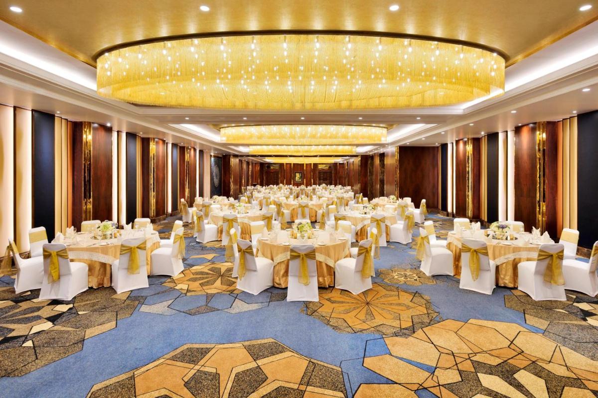a banquet hall with white tables and chairs in a room at Sheraton Grand Pune Bund Garden Hotel in Pune +49 photos