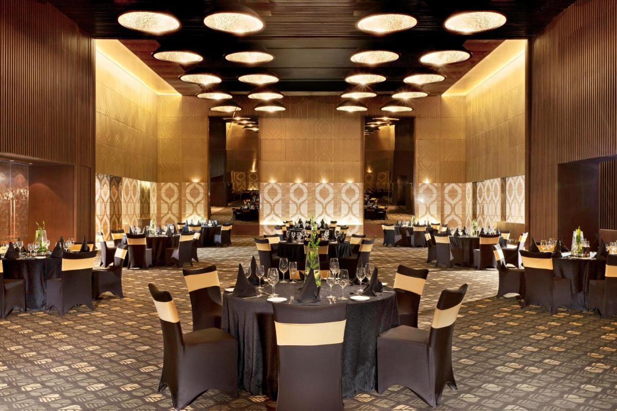 a banquet hall with black tables and chairs at The Westin Gurgaon, New Delhi in Gurgaon