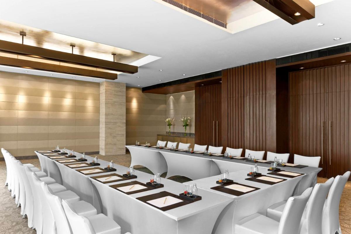 a conference room with a long table and white chairs at The Westin Gurgaon, New Delhi in Gurgaon