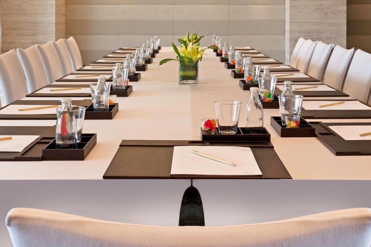 a long table in a room with white chairs at The Westin Gurgaon, New Delhi in Gurgaon