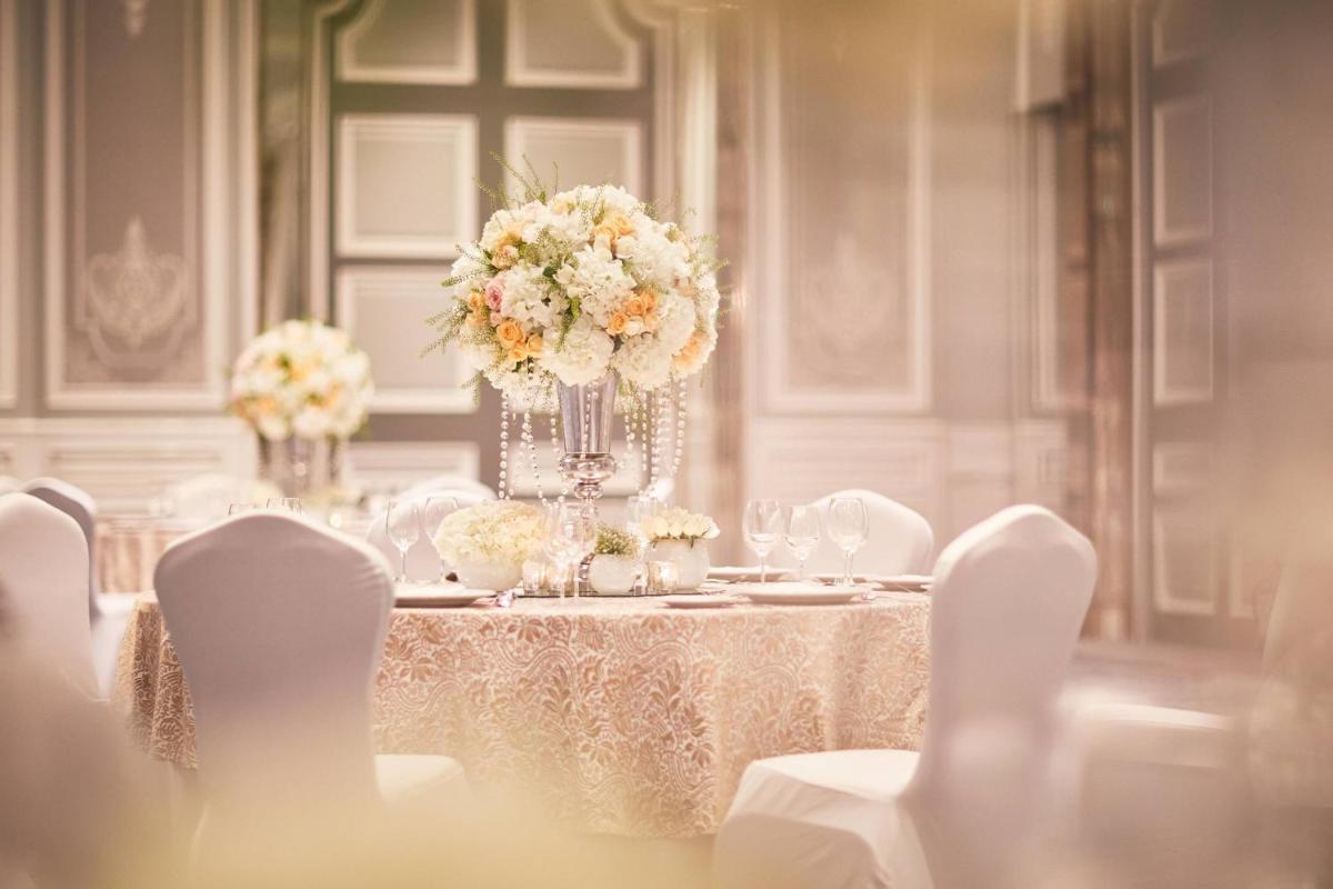 a table with white chairs and flowers on it at The Ritz-Carlton, Pune in Pune