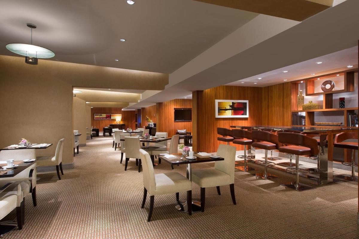 a dining room with tables and chairs in a restaurant at Sheraton Grand Bangalore Hotel at Brigade Gateway in Bengaluru