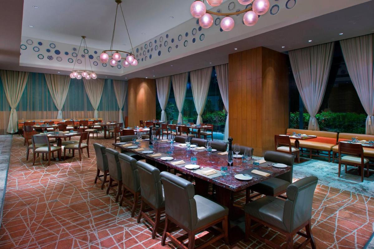 a dining room with a long table and chairs at Sheraton Grand Bangalore Hotel at Brigade Gateway in Bengaluru