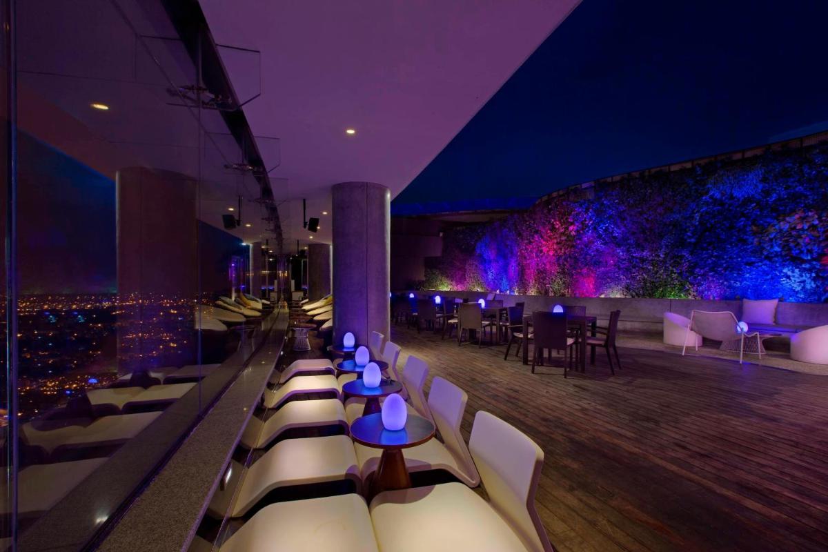 a view of a restaurant with tables and chairs at Sheraton Grand Bangalore Hotel at Brigade Gateway in Bengaluru