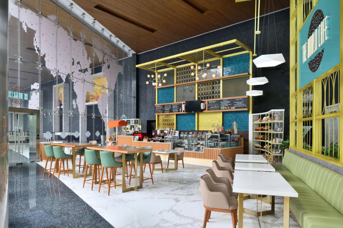 a restaurant with tables and chairs and a bookstore at Sheraton Grand Bangalore Hotel at Brigade Gateway in Bengaluru a restaurant with tables and chairs and a bookstore at Sheraton Grand Bangalore Hotel at Brigade Gateway in Bengaluru